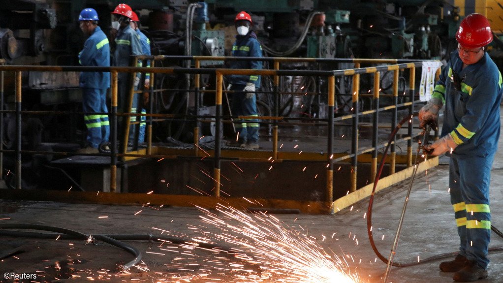 People work in a processing plant at Dinson Iron and Steel Company in Mvuma, Zimbabwe