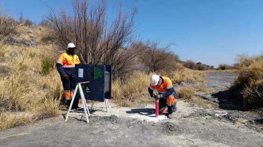 Two men operating a ShapeArray automated inclinometer on sight wearing PPE