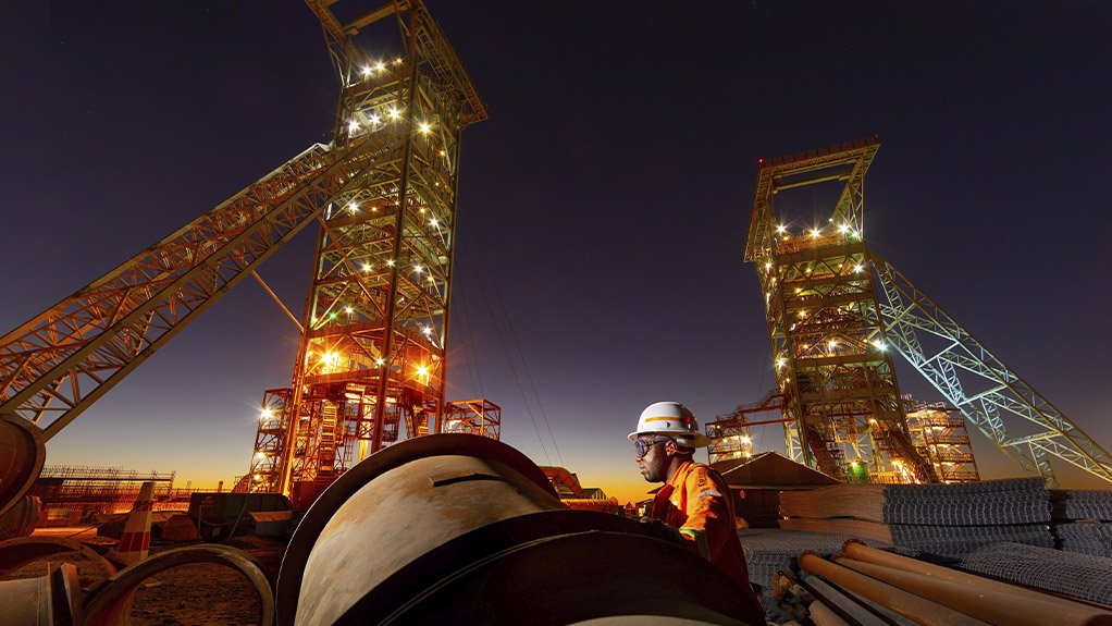 Image of concrete pipes in the foreground and mining headgear in the background