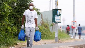 A person in a mask carrying groceries 