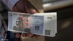 A person holding new ZiG banknotes