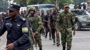 Rwandan security officers escort members of the Armed Forces of the Democratic Republic of the Congo (FARDC), who surrendered in Goma, in the DRC 