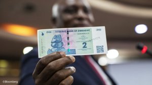 Person holding a ZiG banknote